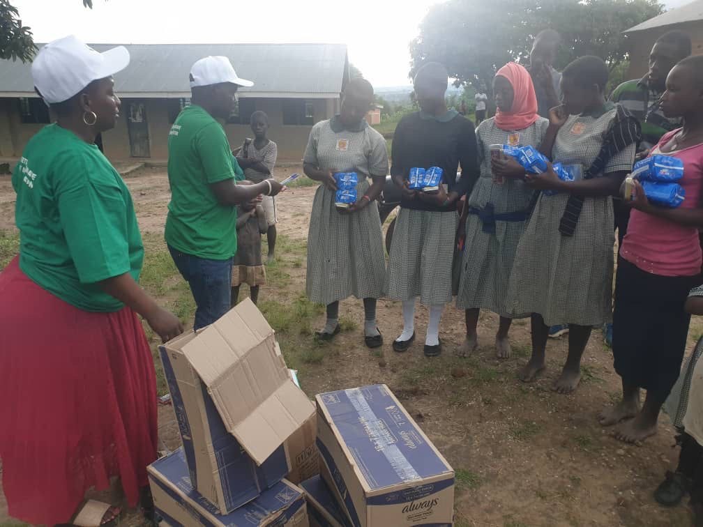 Volunteers distributing hygiene supplies to schoolgirls in Uganda