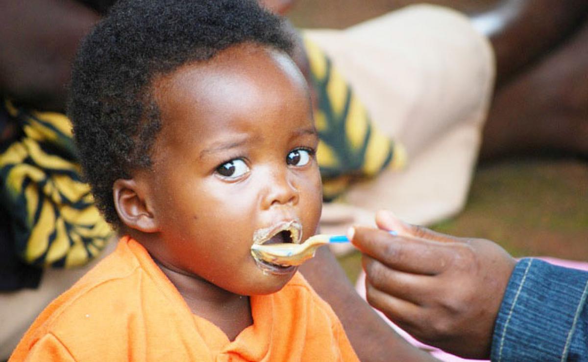 A child in Uganda being fed a nutritious meal — fighting childhood hunger